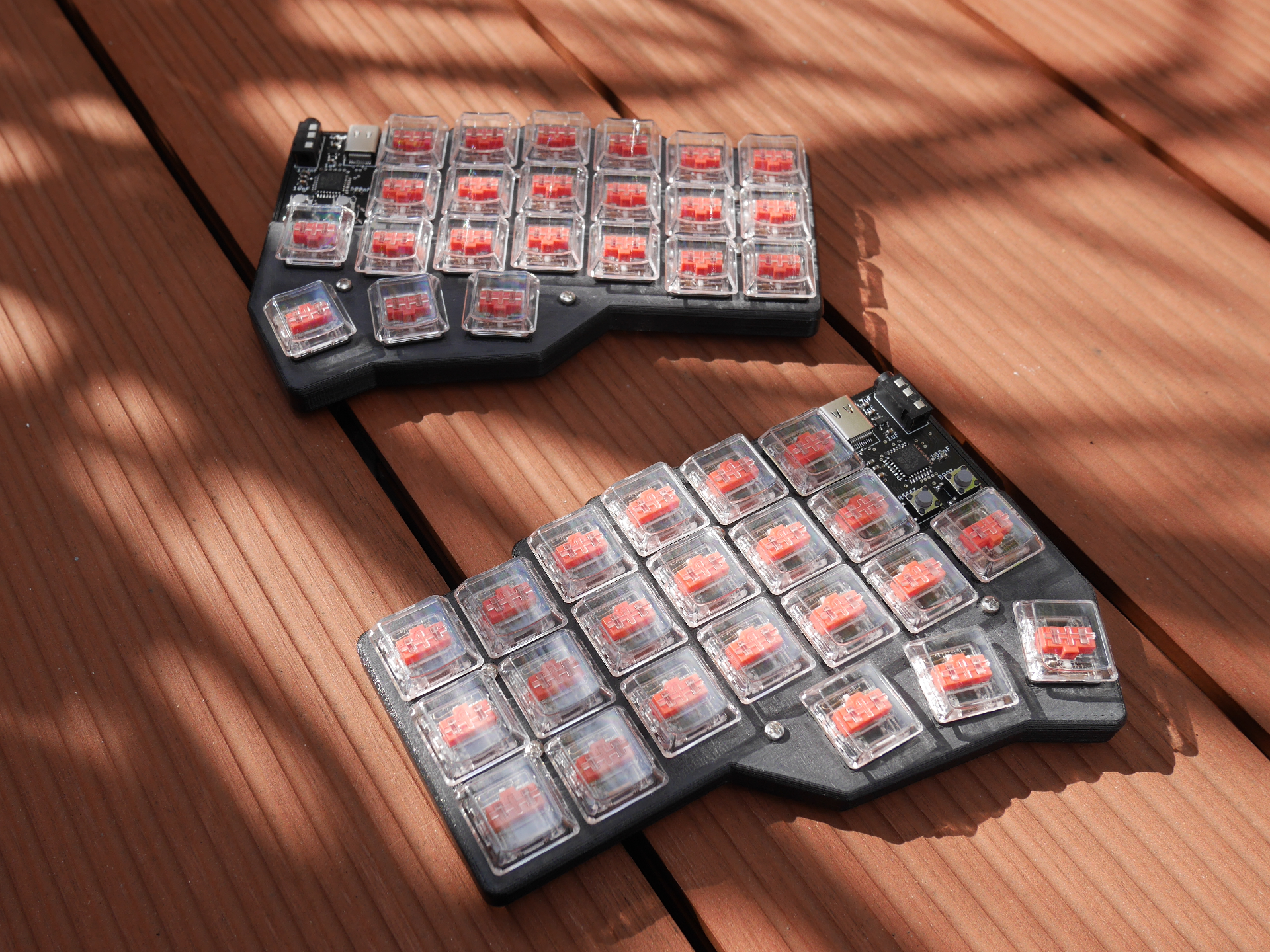 Photo of a split keyboard in the sun on a wooden floor